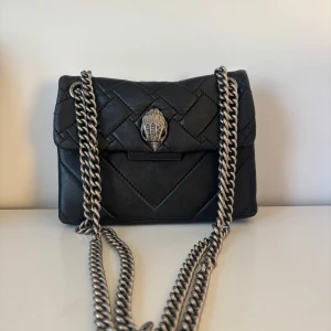 Svart Kurt Geiger väska - Så snygg väska från Kurt Geiger, storlek small!! Passar perfekt till nästan allt och perfekt storlek också, lite sliten vilket visas på bild 4 och 5 men inget man tänker på när man väl använder den🙏🏼🙏🏼Nypris ligger på ca 2000 kr