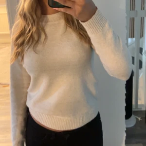 Ljusbeige stickad tröja - Enkel och stilren ljusbeige stickad tröja med rund halsringning och ribbade muddar. Perfekt för lager-på-lager och passar till allt. Mjuk och skön känsla, långärmad och klassisk passform.