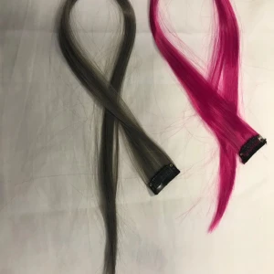 Clip-on hårförlängningar i grått & rosa - Två clip-on hårförlängningar, en i mörkgrå och en i starkt ceriserosa färg. Perfekt för att snabbt byta stil eller lägga till färg i håret. Fästes enkelt med clips. Syntetmaterial.