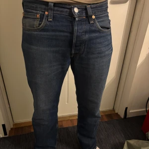Levi's 501 - blå Levi's 501 jeans med rak passform och normal midja. Storlek 30/30, Skick 9/10  Jeansen har fem fickor, knappgylf och den ikoniska läderpatchen bak i midjan. Tillverkade i slitstarkt denimtyg som ger en tidlös look. Bara skriva vid frågor 