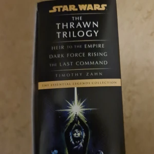 Star Wars: The Thrawn Trilogy (The Essential Legends Collection) - Upptäck Star Wars-universumet med Thrawn-trilogin! Denna box innehåller 'Heir to the Empire', 'Dark Force Rising' och 'The Last Command'. Perfekt för dig som älskar episka äventyr, rymdstrider och ikoniska ljussabelfighter. Mycket bra skick, endast små pappers vikningar på en av böckerna (de andra är olästa)