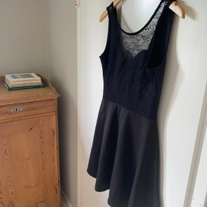 Svart spetsklänning i storlek 40 - Aldrig använd, hängt långt in i garderoben.. Dock har den av oklara anledningar några hål i spetsen där fram trots att den inte är använd, så därav kategoriserar jag den som ”bra” trots att den är oanvänd 🌸
