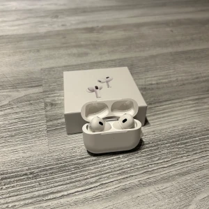 AirPods Pro - Säljer ett par Apple AirPods Pro i mycket fint skick, komplett med originalförpackning. Trådlösa hörlurar med aktiv brusreducering och laddningsetui. Inga synliga repor eller skador, fungerar utmärkt. Perfekt för musik, samtal och träning.