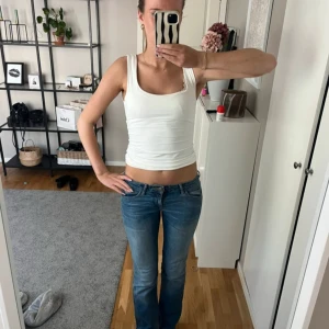 Blå Wrangler lowwaist jeans - Säljer ett par klassiska blå bootcut jeans från Wrangler med snygga detaljer på bakfickorna och låg midja. Innerbenslängd 81cm midjemått rakt över 37-38cm💓