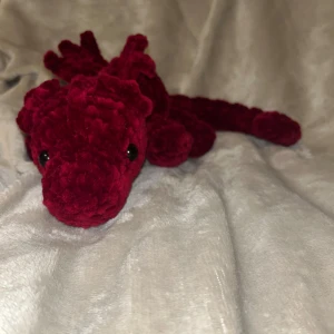 Röd drake  - Röd drake perfekt som dekoration eller som ett gosedjur. Den är ca 45 cm lång och 9 cl bred. Draken har Säkerhetsögon som inte rekommenderas för barn under 3 år! 