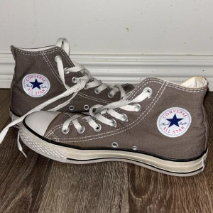 Converse High Tops Skor I Nyskick - Converse Hightops i en jätte snygg färg som är beige/grå aktig! 🩶 Jag köpte dom oanvända på secondhand och har själv endast använt dom en gång, så dom är i nyskick! Superfina och skulle uppskatta storleken mellan 37-38 då dom passar mig! Säljer då dom tyvärr inte kommer till användning 😺