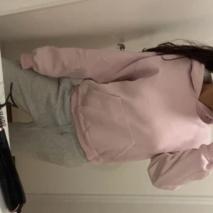 Ljusrosa hoodie  - Säljer en ljusrosa hoodie med stor magficka och huva. Tröjan har en avslappnad passform och är långärmad, perfekt för chill dagar. Mjuk och skön, passar dig som gillar en enkel och stilren look. Knappast använd och är i storlek xs. 
