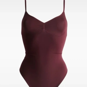 Vinröd body med smala axelband - Skitsnygg vinröd body med smala justerbara axelband. Modellen är enkel och stilren med en djup v-ringning både fram och bak. Materialet är mjukt och stretchigt. Köpt på vinted, aldrig använd av mig. Något tajt på mig som vanligtvis använder xs/s🤍🤍
