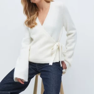 Vit/ beige omlottkofta💓 - Superfin vit omlottkofta från Gina Tricot!med knyt i sidan och djup v-ringning. Koftan är stickad och har långa ärmar med ribbade muddar. Säljer den för att jag har växt ut den så kommer dessvärre inte till andväning. Pris kan diskuteras!☺️