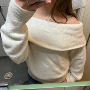 Offshoulder vit stickad tröja - Supermysig offshoulder stickad tröja i vit färg med bred krage som går över axlarna. Tröjan har långa ärmar. Perfekt för dig som vill ha en chill och snygg look med lite extra edge.🍂 När man har på sig tröjan syns inte fläckarna på sista bilden men om man ändå inte skulle vilja se något spår av fläckarna går dem säkert att ta bort!❤️