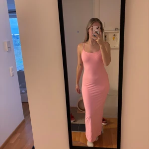 Rosa långklänning med smala axelband - Enkel och snygg rosa långklänning med smala axelband och rak passform. Klänningen är ärmlös och har en mjuk, stretchig känsla som gör den superbekväm. Annonsen finns på flera ställen så skriv till mig innan ni trycker på köp🫶🏻