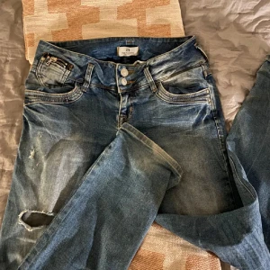 Blå slitna jeans från ltb - Säljer ett par blå jeans från ltb med snygga slitningar och hål på benen. Jag har även sytt om byxorna till bootcut så skriv om vi vill ha fler bilder på det!