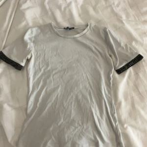 Vit topp med glittriga svarta ärmslut - Snygg t-shirt från Zara