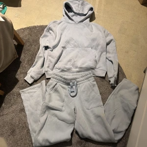 Ljusblå mjukisbyxor från 157 XS - Ljusblå mjukisbyxor från 157 i storlek XS. Byxorna har resår i midjan med snörning, två fickor fram och två bakfickor. Tillverkade i mjukt och skönt material, perfekta för chill dagar. Snygg och enkel design som passar till hoodie eller t-shirt.