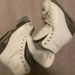 Vita konståkningsskridskor  - Snygga vita konståkningsskridskor från Tempish med gulddetaljer och snörning. 