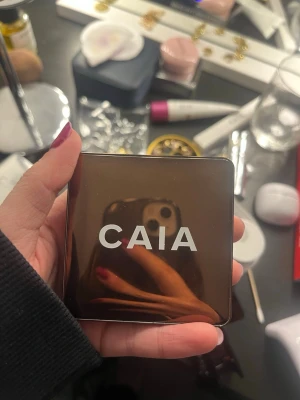 CAIA Glow Bronzer Gold Coast - Snygg bronzer från CAIA i nyansen Gold Coast. Kommer i en lyxig, guldig fyrkantig dosa med spegel. Pudret har en skimrande finish och är pressat i ett cirkulärt mönster. Perfekt för att ge ansiktet en solkysst look.