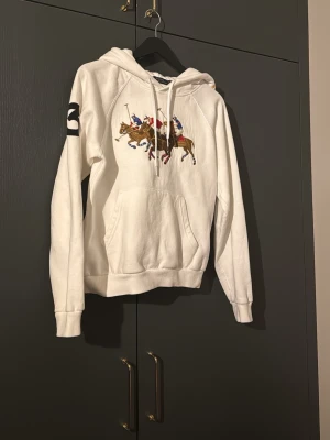Ralph lauren hoodie - Snygg hoodie från Ralph lauren. Den är i nytt skick och har endast använts få antal gånger. Ny pris är 3000kr och den säljs inte längre så passa på!!
