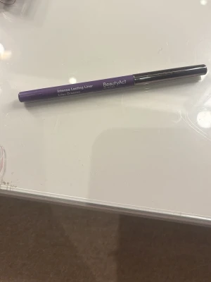 Lila eyeliner BeautyAct Lilac Dreams - Säljer en Intense Lasting Liner i färgen Lilac Dreams från BeautyAct. Eyelinern är i en snygg lila nyans och har en smidig pennform med vridmekanism. Perfekt för att skapa kreativa och färgstarka ögonlooks. Pennan har ett metallfärgat lock.