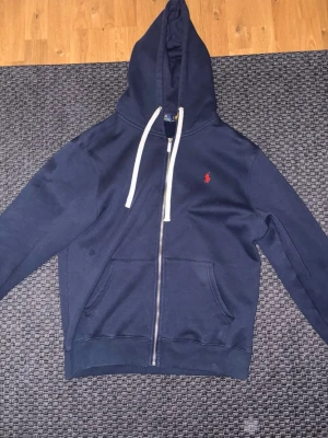 Ralph luran zip up hoodie  - En marinblå hoodie från Ralph luran. Den är i super bra skick inte använd mycket för den är super stor på mig och jag är 172