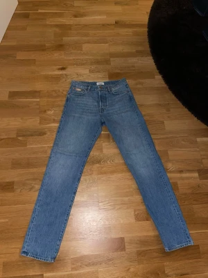 Blå jeans från Jack & Jones ( Relaxed Chris )  - Säljer ett par klassiska blå jeans från Jack & Jones med rak passform och normal midja. Jeasnen är helt oanvända också! Jeansen har storlek 30/34 och har fem fickor, bälteshällor och snygga kopparfärgade nitar. Tillverkade i slitstarkt denimtyg av bomull. Perfekta till en avslappnad stil.