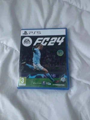 EA Sports FC 24 (PS5) - EA Sports FC 24 till PlayStation 5 i mycket fint skick. Komplett med fodral och skiva, inga synliga repor eller skador. Upplev den senaste fotbollssimulatorn med HyperMotion-teknologi och autentiska lag och spelare. Perfekt för fotbollsfans! Fraktar inom 24 timmar!                                                   ⭐️ ALLTID NÖJDA KUNDER ⭐️
