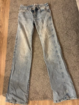 Ljusblå bootcut jeans med snörning - Säljer ett par ljusblå bootcut jeans från Lager 157 i storlek XS. 