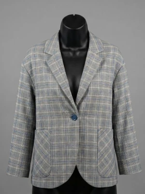 Grå rutig kostym från VOVK - Säljer en snygg tvådelad kostym från VOVK med grått rutigt mönster. Kavajen har en oversized passform, stora fickor och en knapp framtill. Shortsen har resår i midjan och samma rutiga design. Perfekt för dig som gillar stilrena och trendiga plagg.