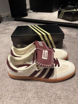 Adidas Wales Bonner Samba sneakers - Säljer ett par riktigt unika Adidas Wales Bonner Samba sneakers i vitt och vinrött. Skorna har ylle matrial där mockan oftast brukar vara och är riktigt lyxiga. Skorna är aldrig använda.