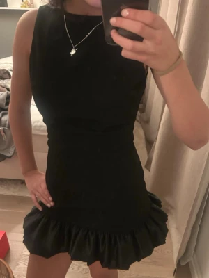 Festklänning - Så himlaaaa snygg festklänning! Klassisk svart med fina volanger nedtill och en super snygg öppen rygg baktill (har ingen bild på när man ser ryggen, men kan fixa om man vill). Älskarrrrr den här klänningen, säljer då jag har två därmed oanvänd💕köpt utomlands! Pris kan diskuteras
