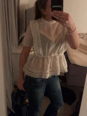 Vit spetsblus från Gina Tricot - Superfin vit blus från Gina Tricot i storlek 38. Blusen är helt i spets med vackra broderade detaljer och korta ärmar. 