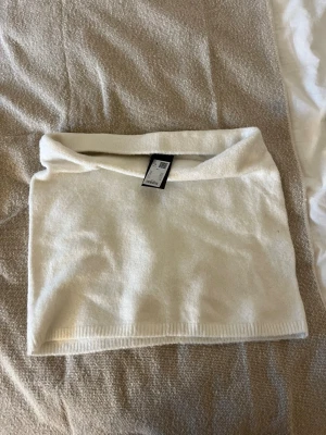 Vit bandeau tubtopp från 157 - Säljer en enkel och stilren vit bandeau tubtopp från 157. Toppen är ärmlös och har en mjuk, lite stretchig känsla. Perfekt att matcha med jeans eller kjol för en clean look. Materialet känns som bomull eller syntet och toppen har ribbad kant nertill.