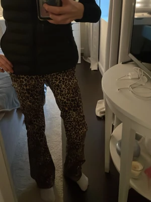 Leopardmönstrade bootcut byxor - Säljer ett par riktigt snygga byxor med leopardmönster. De har bootcut passform och är i ett mjukt, stretchigt material som sitter skönt på kroppen. Perfekta för dig som vill sticka ut och addera lite edge till din outfit.