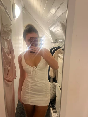 Studentklänning - Supersnygg vit kort klänning med smickrande passform och snörning framtill. Funkar perfekt som studentklänning eller bara till sommaren🌸