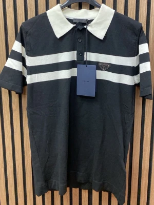 Svart och vit randig tröja  henley - Snygg svart med vita horisontella ränder och vit krage. Skjortan har korta ärmar, . Tillverkad i mjuk bomull för en skön känsla.