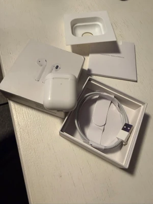 Apple AirPods (2nd Generation) med laddningsetui - Säljer ett par Apple AirPods (2nd Gen) med originalförpackning, laddningsetui och laddningskabel. Perfekt för trådlös musik och samtal med smidig laddning.