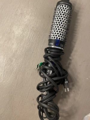 Rundborste med värme och jonfunktion - En elektrisk rundborste från OBH Nordica med keramisk och turmalinbeläggning. Borsten har svarta piggar och ett silverfärgat borsthuvud med ventilationshål. Utrustad med sladd och EU-kontakt. Perfekt för att styla och skapa volym i håret.