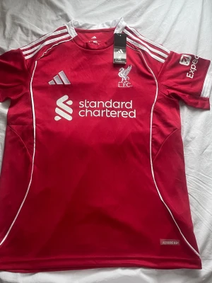 Liverpool matchtröja – HELT NY - Säljer en Liverpool-tröja som aldrig har använts. Inga fläckar, inga skador – helt ny i perfekt skick. Skönt material och snygg, klassisk Liverpool-design. Perfekt för match, träning eller vardag.