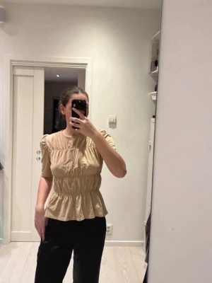 Beige blus med puffärm och volang - Säljer en beige blus med puffärmar och volanger från Gina Tricot! Använd ett fåtal gånger så är i jättebra skick!! Storlek L men är LITEN i storleken så den passar S/M⭐️