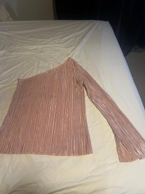 Rosa one-shoulder topp - Rosa glittrig one-shoulder topp som jag misstänker är från gina, men lappen är bortklippt. Jag köpte den här och vet därför inte. Snygg passform. 