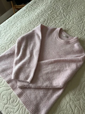 Ljusrosa stickad tröja Gina Tricot - Supermjuk ljusrosa stickad tröja från Gina Tricot i storlek S. Tröjan har rund halsringning, ribbade muddar och är långärmad. Perfekt för dig som gillar en enkel men söt look till höst och vinter. Använd få gånger