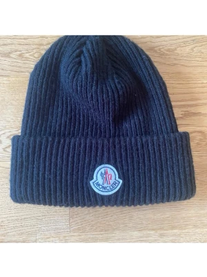 Moncler Mössa - Säljer en fin Moncler mössa i nyskick bara testad på en gång perfekt nu till våren. Skriv om ni har frågor:) 