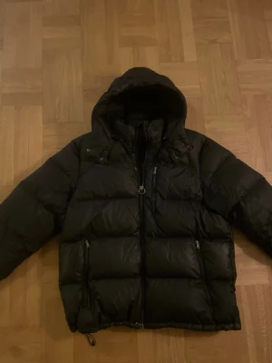 Ralph Lauren Dunjacka  - Riktig snygg äldre modell av Ralph laurens dunjacka med en snygg svart logga på bröstet. Bra skick men har använts ett tag, men ingen defekt. Storlek XL. 