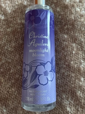 Christina Aguilera Moonlight Bloom Body Mist 220ml - Fräsch body mist med ungdomlig vibe från Christina Aguilera. Innehåller 220ml kvar. Ingredienser: Alcohol Denat., Aqua/Water/Eau, Parfum (Fragrance), Benzyl Alcohol, Benzyl Salicylate, Linalool, Geraniol, Hydroxycitronellal, Limonene. Tillverkad i Spanien.