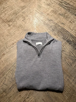 These glory days  - Snygg grå långärmad tröja från These Glory Days i mjuk och exklusiv merinoull. Tröjan har en stilren half zip-dragkedja vid halsen och riktigt bra passform. Personen på bilden är 195 och den sitter bra, 185-2.00 är perfekt längd. Hör av dig vid minsta fråga!