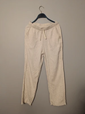 Beiga linnebyxor Grunt - Säljer ett par beiga linnebyxor från Grunt i storlek L. Byxorna har elastisk midja med snörning och raka ben. Använd fåtal gånger och helt fri från defekter. Priset är inte hugget i sten och det är bara att höra av sig vid frågor och funderingar!