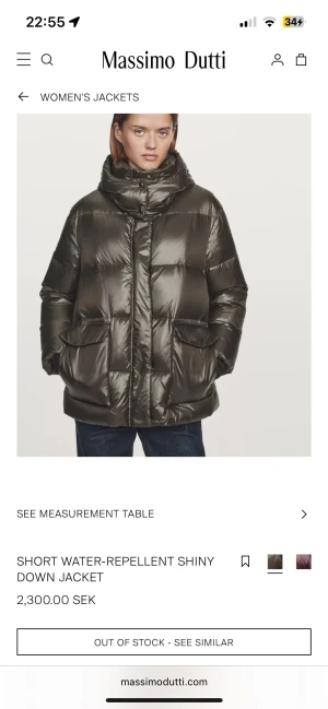 Massimo Dutti jacka - Snygg mörkgrön, glansig dunjacka med vattenavvisande yta och hög krage. Jackan har en oversized passform, stora fickor framtill och dragkedja med knappslå. Perfekt för kalla dagar när du vill ha både stil och komfort.