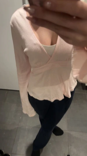 Ljusrosa omlottblus från Gina Tricot - Säljer en ljusrosa omlottblus från Gina Tricot i storlek XS. Blusen har långärmade ärmar, v-ringad hals och knytband i ryggen . Säljer för jag inte använder:) 