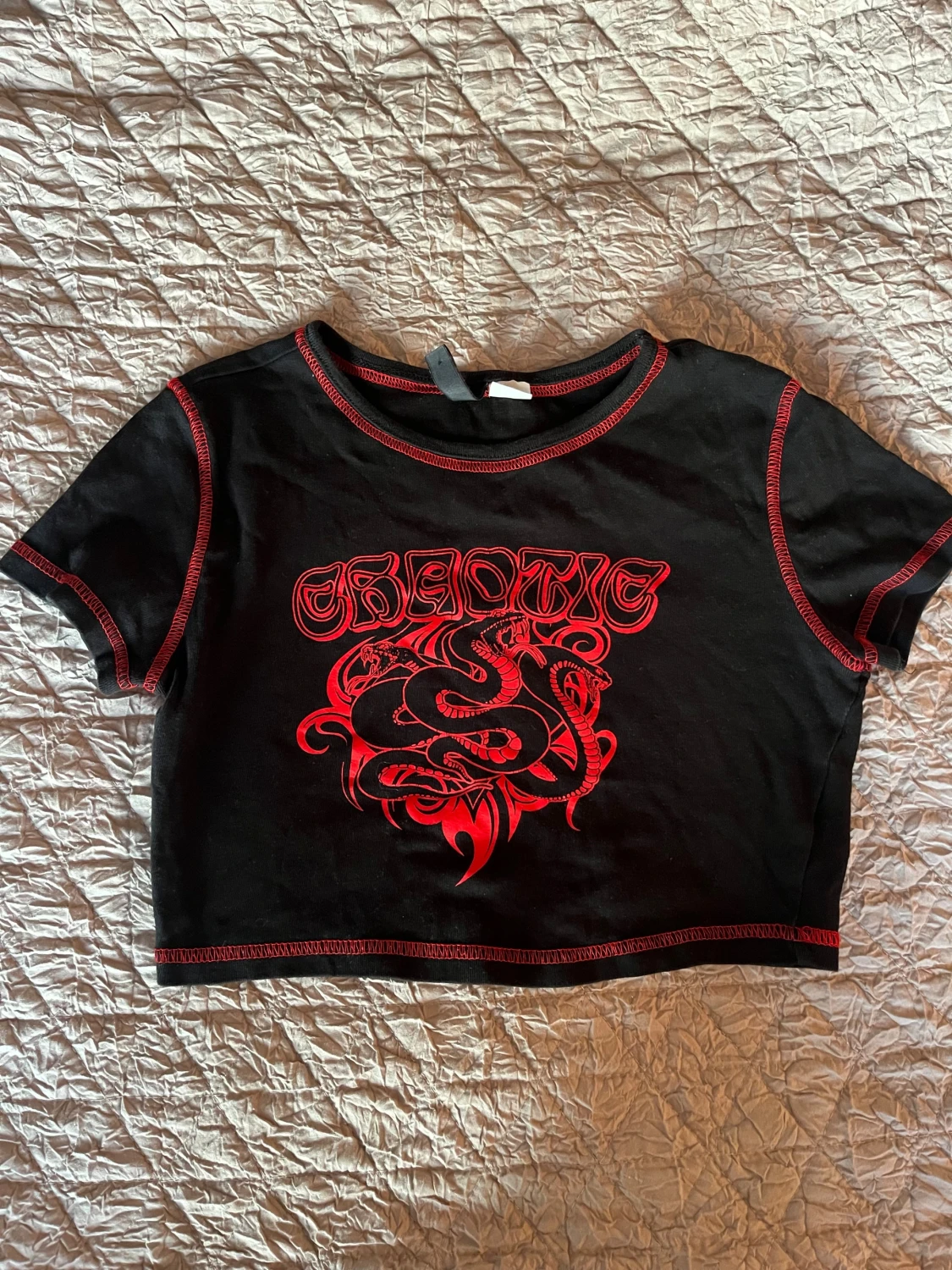 Svart croppad topp med röd print från DIVIDED