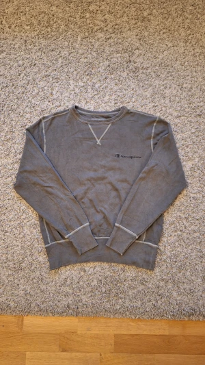 Olivgrön Champion sweatshirt - Snygg olivgrön sweatshirt från Champion i storlek S(passar XS också). Använd fåtal gånger och skicket är jättebra, inga defekter eller slitningar finns. Tröjan har dock lite creasningar, men det går bort enkelt med lite strykning. Den har logga på vänstra ärmen och vänstra bröstet. Skick: 8.5/10