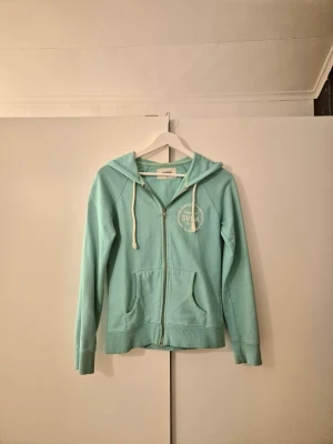 Zip-up  - Zip-up i en väldigt cool turkos färg. Den har ett snyggt tryck både fram och bak. Säljer då jag inte har samma stil längre men jag har tyckt om den mycket 